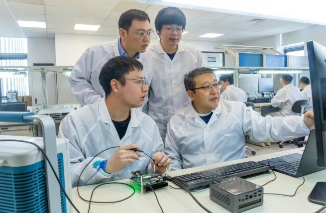 窦强(前排右一)与研发团队进行新产品调试 窦强(前排右一)与研发团队进行新产品调试